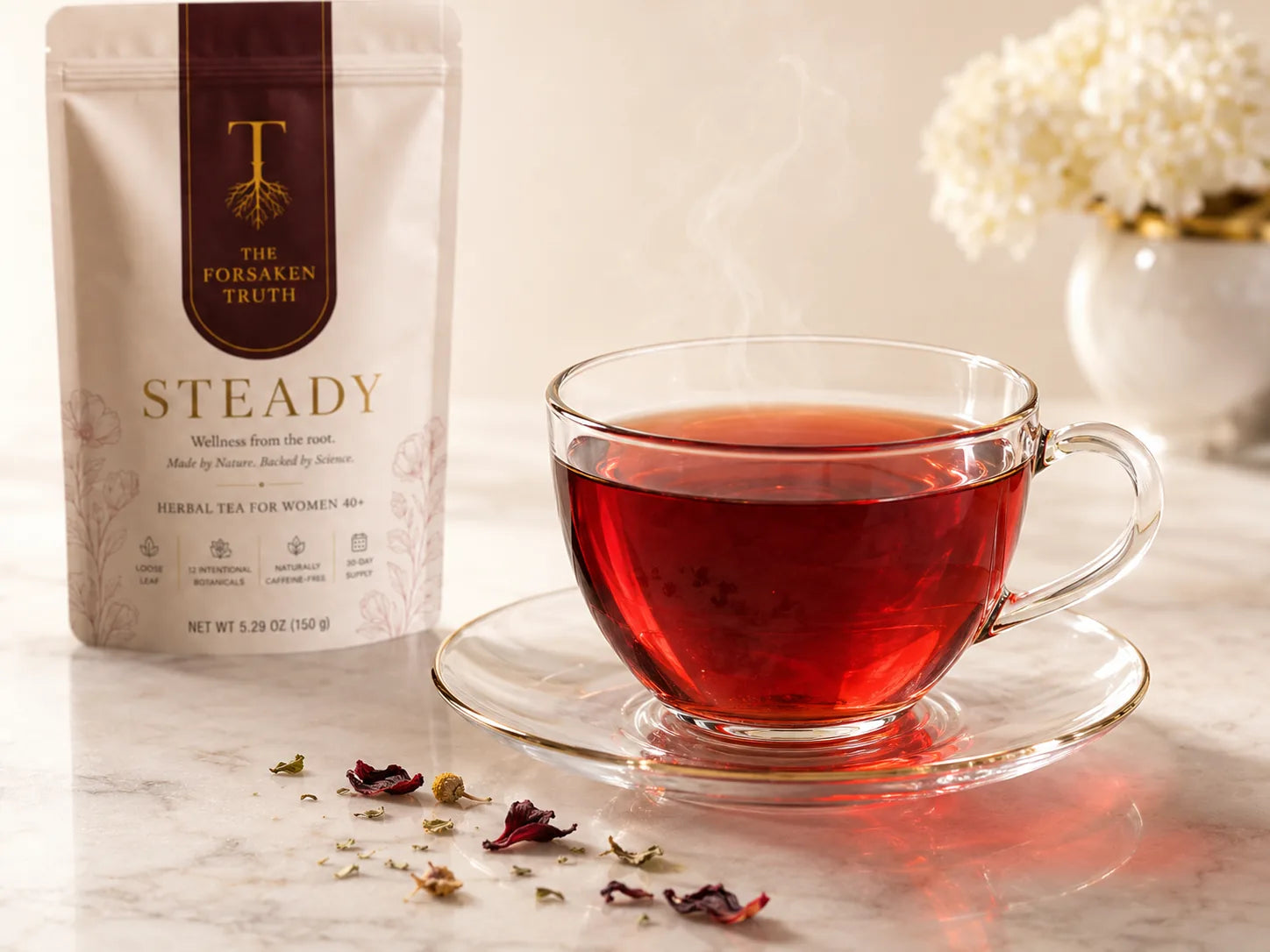 Ruby red cup of STEADY tea beside the pouch